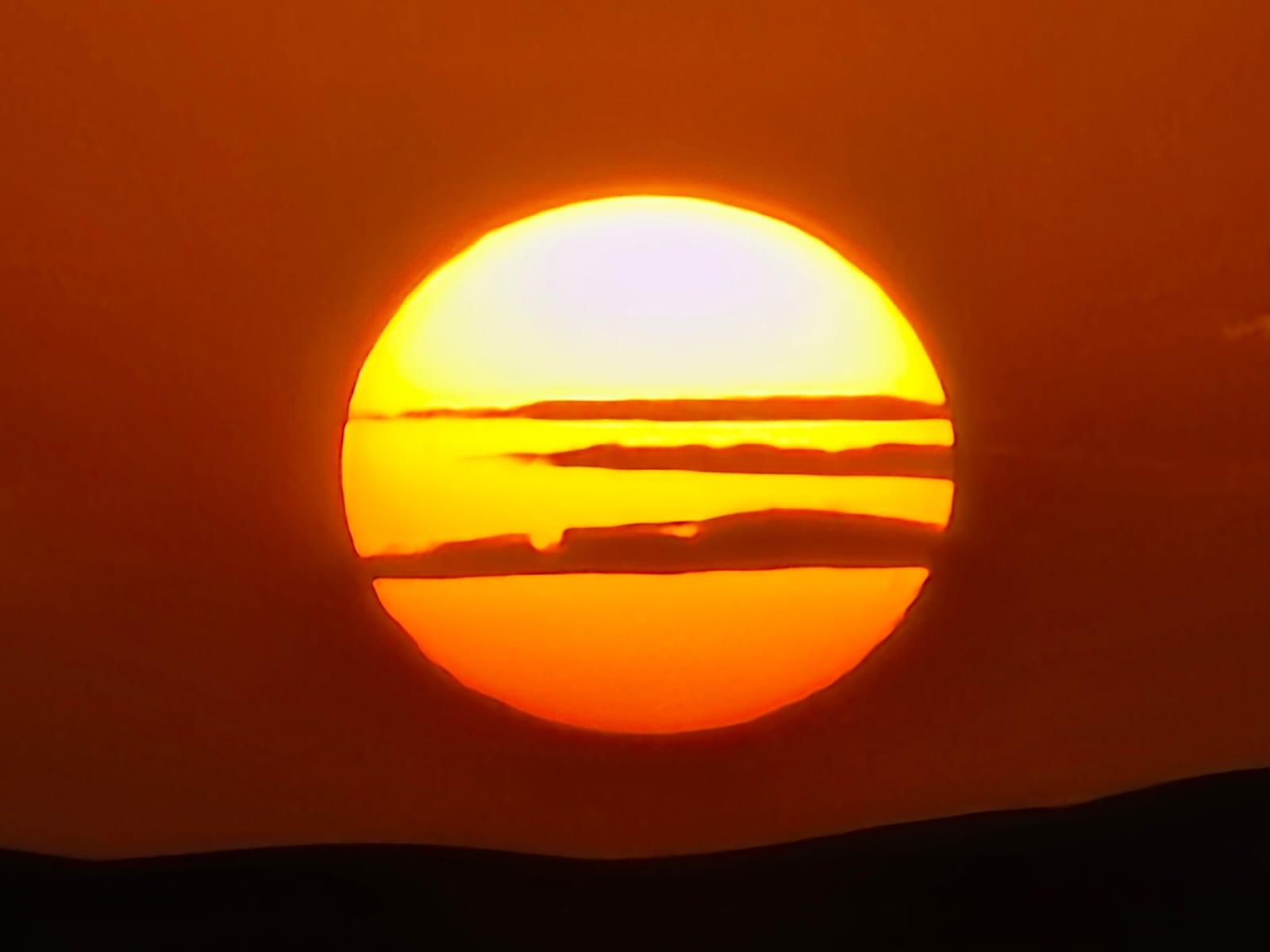 Sol enorme descendiendo sobre el horizonte del desierto