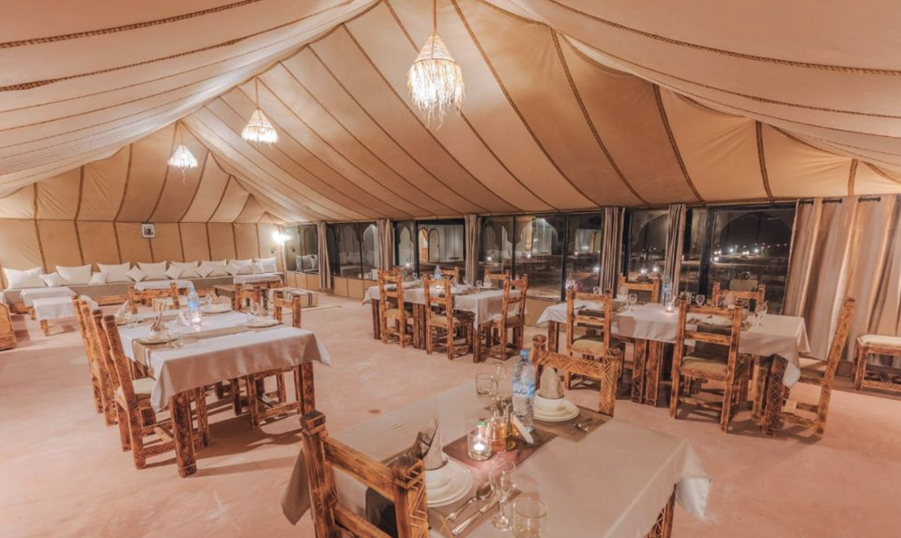 Interior de la jaima comedor con mesas y lámparas artesanales